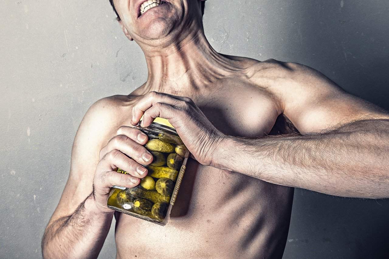 גבר בלי חולצה פותח צנצנת זיתים